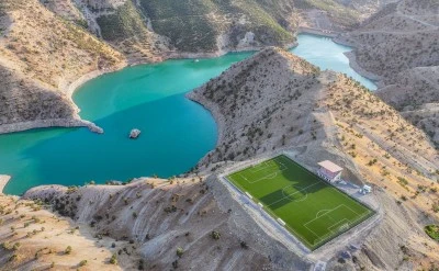 Gen&ccedil;lerin tarladan baraj g&ouml;l&uuml; manzaralı stada uzanan futbol &ouml;yk&uuml;s&uuml;