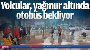 Yolcular, yağmur altında otob&uuml;s bekliyor